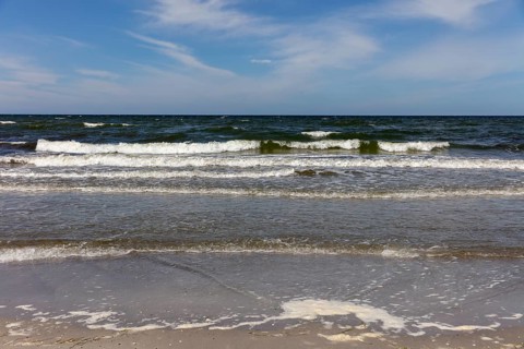 Foamy waves crash onto the coast in sunny weather and blue skies, Rügen, Hiddensee