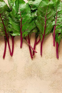 Fresh, green leaves, stem with beet leaves, on the table, top view, rustic, no people