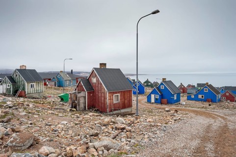 Colourful houses and gravel road with street lamps on a fjord, remote Arctic Inuit settlement