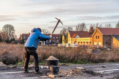 Climate activists chop up the asphalt of a road to erect obstacles, barricades, to prevent the