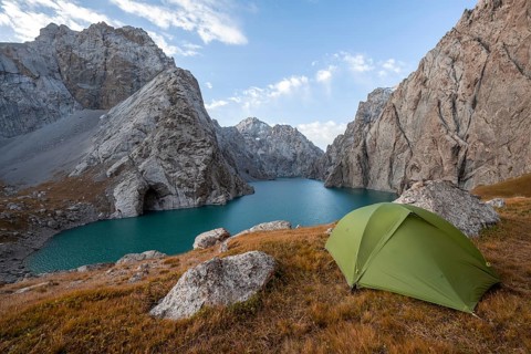 Wild camping, camping in the wilderness with a tent in front of mountain lake Kol Suu, Sary Beles