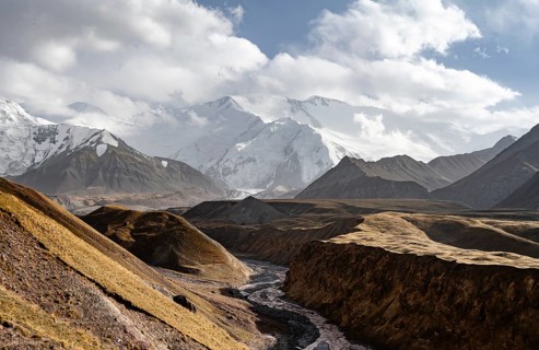 Achik Tash river, Achik Tash valley, behind glaciated and snow-covered mountain peak Pik Lenin,