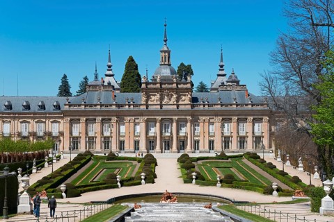 Historic palace with symmetrical formal garden and sculptures in sunny weather, Royal Castle La