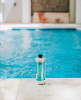 Bottle of algicide for cleaning home pools. Algicide powder for cleaning and purifying swimming