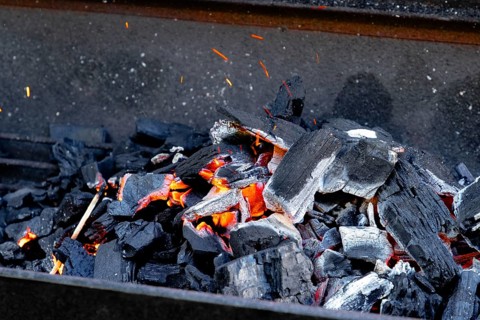Hot glowing charcoal with sparks and flames, ready for grilling
