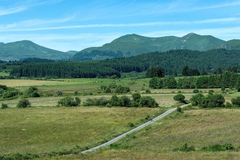 Hikers stroll along a path at the foot of the Monts Dore in the picturesque Auvergne Volcanoes