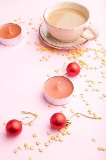 Christmas or New Year composition. Decorations, red balls, cup of coffee, on a pink paper