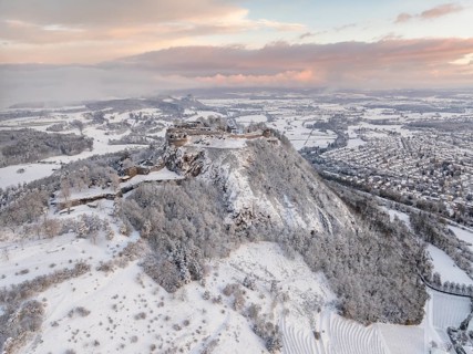 Aerial view of the snow-covered Hegau volcano Hohentwiel with Germany's largest castle ruin on a
