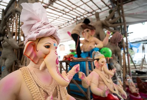 An artisan decorates an idol of the elephant-headed Hindu deity Ganesha at a workshop ahead of the