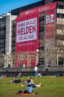 A construction company has hung a large poster on a building facade on the Rhine promenade,