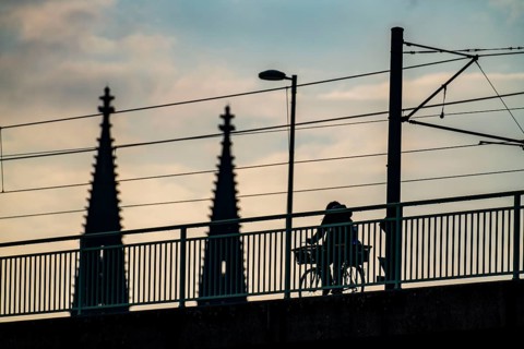 Cycling in the city, cyclist on the Deutzer Bridge in Cologne, Cologne Cathedral, cycle path, North