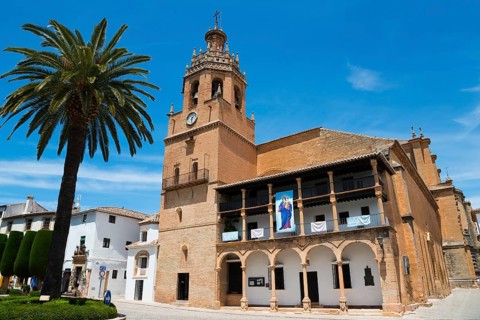 Historic church with bell tower and palm trees under a bright blue sky, Church, once a Moorish