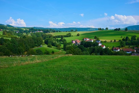 Green hills with scattered rural houses under a clear blue sky, Wachtküppel, Gersfeld, Rhön, Hesse,