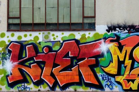 Colourful graffiti artwork with red letters on an urban wall with window, Rhineland-Palatinate,