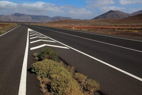 Chevron road lines on main highway through Malpaís Grande national park, Fuerteventura, Canary