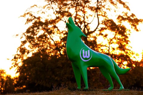 Green wolf sculpture with VfL Wolfsburg logo at sunset, Wolfsburg, Lower Saxony, Germany, Europe