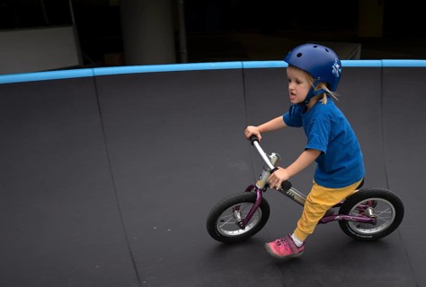 Little girl, 3 years, blonde, helmet, helmet, riding on balance bike, bicycle, skating rink,