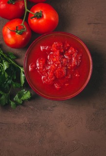 Tomatoes in their own juice, sliced, tomato sauce, tomatoes, in a cup, top view, close-up, no