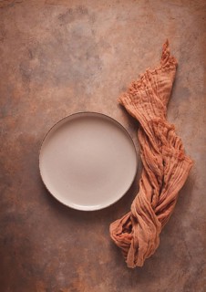Beige plate, empty, on a beige-brown background, rust effect, no people