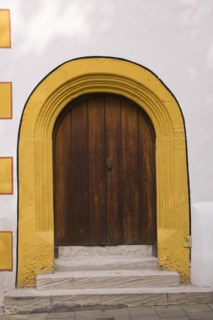 Old wooden entrance door with doorstep and yellow contour on facade of Stadtsall hotel building in