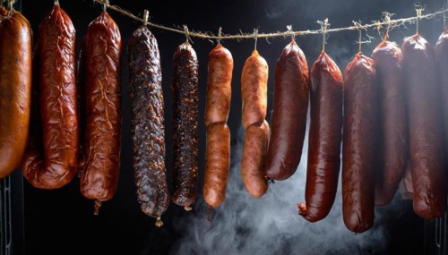 Food, various smoked sausages hanging on a string next to each other in the smoker, AI generated,