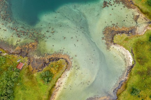 Aerial view of a bay at the Raftsund, single hut with boat, fjord between Lofoten and Vesteralen,