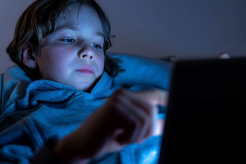 A boy plays computer games on a tablet PC