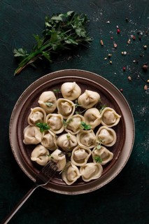 Dumplings, on a dark background, with spices and herbs, vertical, no people