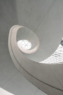 Modern architecture with a spiral design and natural lighting through a geometric glass skylight,