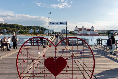 Red heart with castles on a pier with a view of the Seebad Binz building, Rügen, Binz