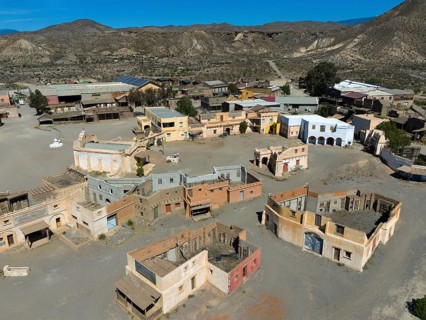 Close-up of an abandoned Wild West town with various buildings in the desert, aerial view, Fort