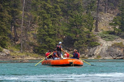 Tourists in inflatable raft rafting on the Bow River near Banff, Alberta, Canada, North America
