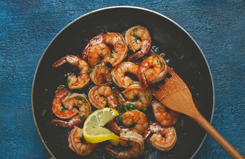 Fried tiger prawns, jumbo, in garlic sauce, in butter, with herbs, in a frying pan, homemade, no