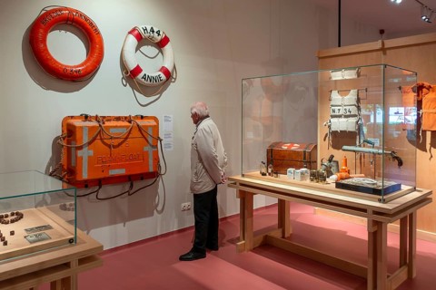 Elderly visitor looking at maritime exhibition at NAVIGO Visserijmuseum, fishery museum at
