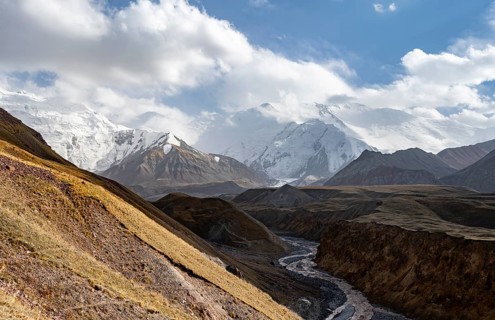 Achik Tash river, Achik Tash valley, behind glaciated and snow-covered mountain peak Pik Lenin,