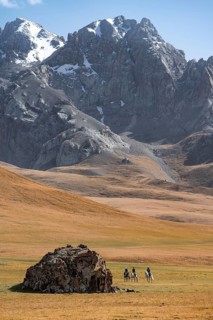 Rider in front of mountain landscape with yellow meadows, mountain peak, Keltan Mountains, Sary