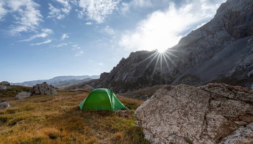 Wild camping, camping in the wilderness with a tent in front of mountain lake Kol Suu, Sary Beles
