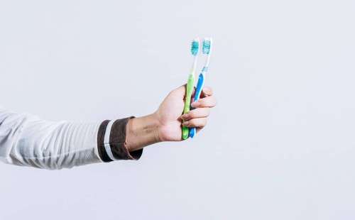 Toothbrush change concept. Hand holding two toothbrushes isolated. Oral health concept