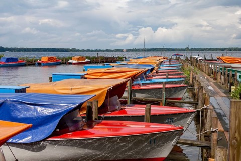 Colourful boats anchored at a wooden jetty, under a cloudy sky, Bad Zwischenahn, Zwischenahner