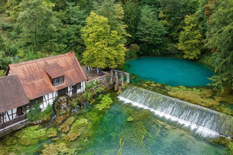Blautopf Blaubeuren with industrial monument Hammerschmiede, source of the little river Blau in a