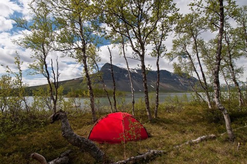 Tent on an island in Lake Laitaure, Mount Tjahkkelij in the background, Sarek National Park,