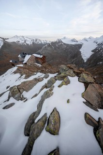 Snow-covered mountain landscape, mountain hut Ramolhaus in autumn with snow, at sunset, view of