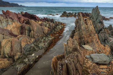 Colourful rocks by the sea, cloudy, Varanger Peninsula, Norway, Europe