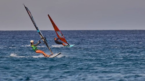 Two people windsurfing on the open sea under a clear sky, windsurfer, Meltemi windsurfing spot,