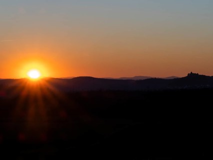 Sunset over the Kellerwald national park in autumn, with the town of Waldeck church and surrounding