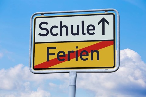 School start symbol: Town exit sign with the terms HOLIDAYS and SCHOOL (Composing)