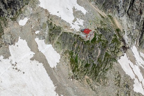 Aerial view of mountain hut Cabane de l'A Neuve, located on a steep rock formation, near La Fouly,