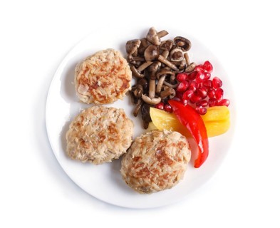Meatballs with rice mushrooms, sweet peppers and pomegranate seeds isolated on white background.