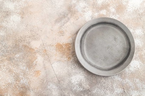 Empty gray ceramic plate on gray concrete background. Top view, copy space, flat lay