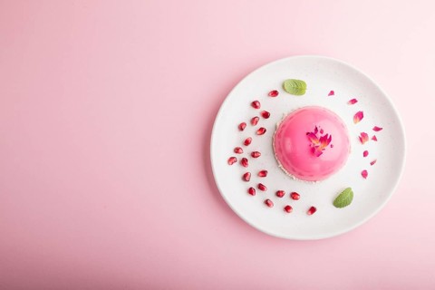 Pink mousse cake with strawberry on a pastel pink background. top view, flat lay, copy space